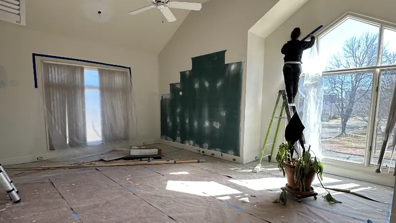 CrewPros remodeling putting up plastic to block dust.