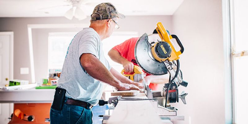 Two men completing home repairs with a buzzsaw.