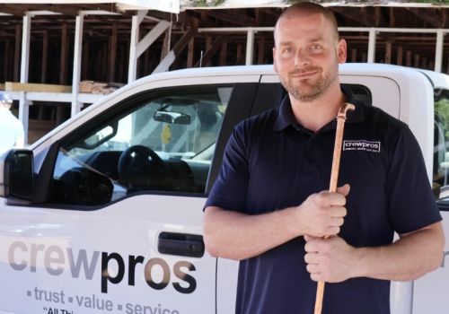 CrewPros technician holding a copper water pipe.